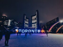 a group of people standing in front of a sign that says toronto